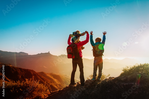 happy family travel in mountains at sunset