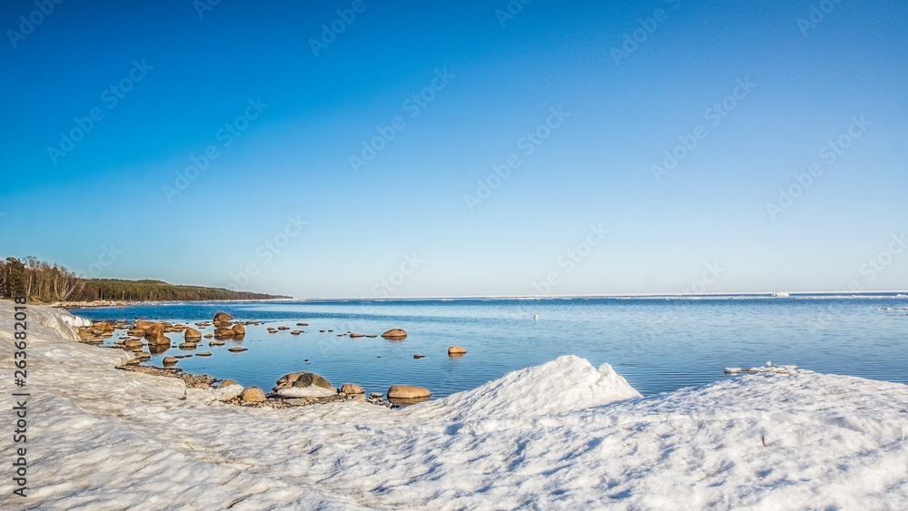 Snow pile, hill. Large snow drift isolated on a blue sky background, outdoor view of ice blocks at frozen finland lake in winter Snow pile, hill. Large snow drift isolated on a blue sky background, outdoor view of ice blocks at frozen finland lake in winter