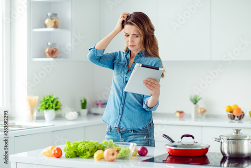 Portrait of her she nice lovely attractive confused brown-haired lady thinking how to prepare fresh hot dish meal dinner lunch green eco delicacy in light white interior style kitchen