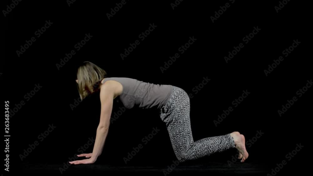 Full body side view of a woman demonstrating various yoga poses including downward dog, child pose and cobra pose isolated on a black studio background Full body side view of a woman demonstrating various yoga poses including downward dog, child pose and cobra pose isolated on a black studio background