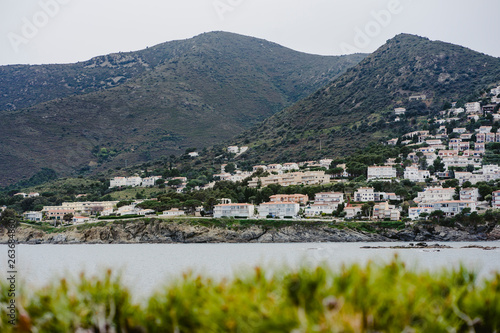 Landscape of coast with land, grass, beach, sea and a coastal town near the ocean. photo