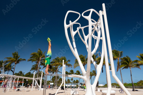 South Beach, Florida. man standing on his hands on parallels bars photo