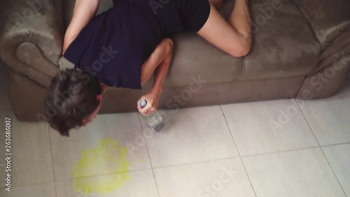 high angle of a boozy woman puking on the floor while laying on the sofa photo