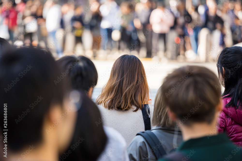 渋谷スクランブル交差点の信号待ちの若い女性の後ろ姿 渋谷スクランブル交差点の信号待ちの若い女性の後ろ姿