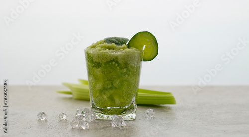 Nutritious celery cocktail for weight loss and maintaining a healthy lifestyle. In cocktail added cucumber and green leaf. There are also a few celery stalks and pieces of ice.