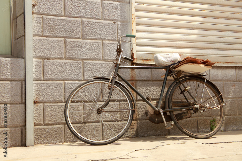Rusty old bicycle leaning against brick wall Rusty old bicycle leaning against brick wall