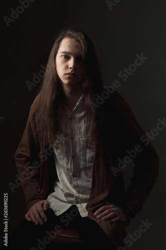 Portrait of young man with long hair. Low key