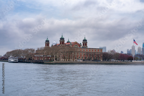Historic Ellis Island stands under a dramatically cloudy sky on a New York City spring morning
