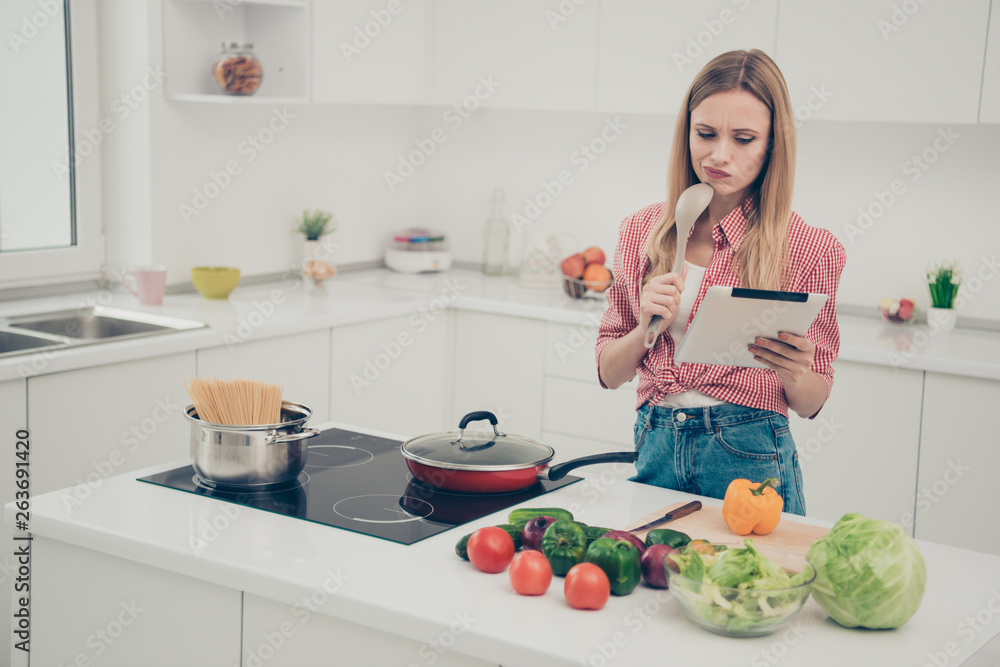 Close up photo beautiful amazing she her lady hold hands arms e-reader unsure uncertain doubtful recipe true homey wear domestic home apparel shirt jeans denim outfit bright flat home kitchen indoors
