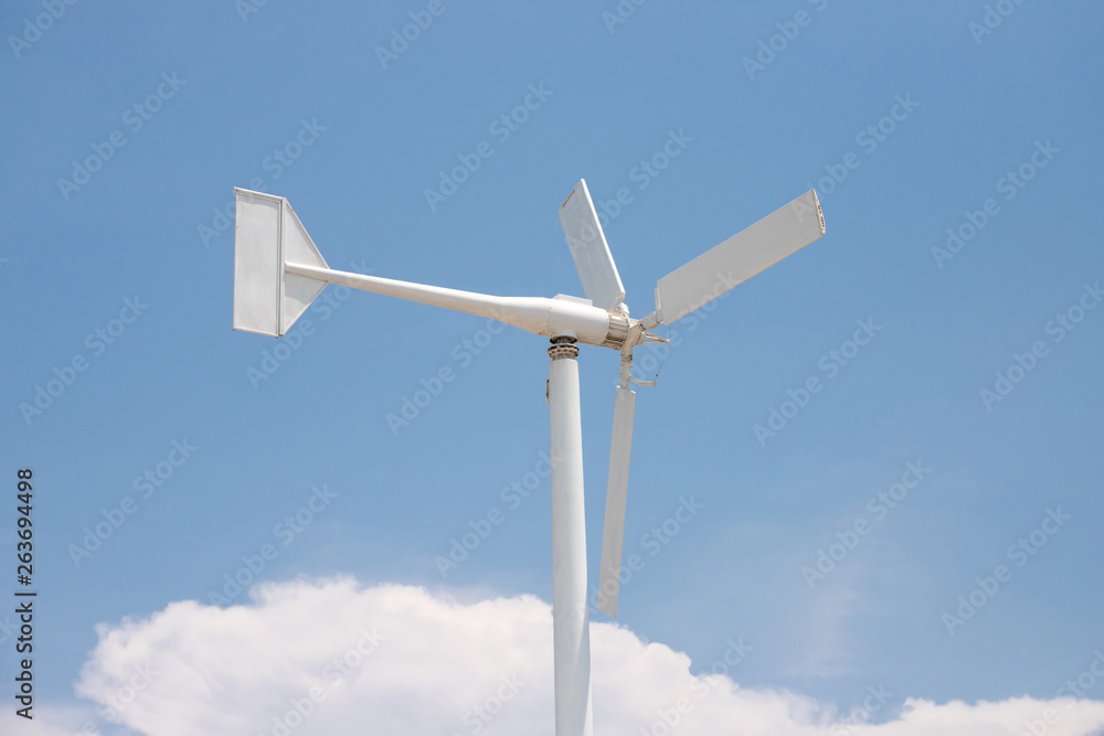 white wind turbine against blue sky with white cloud. concept: clean energy, resolve air pollution. white wind turbine against blue sky with white cloud. concept: clean energy, resolve air pollution.