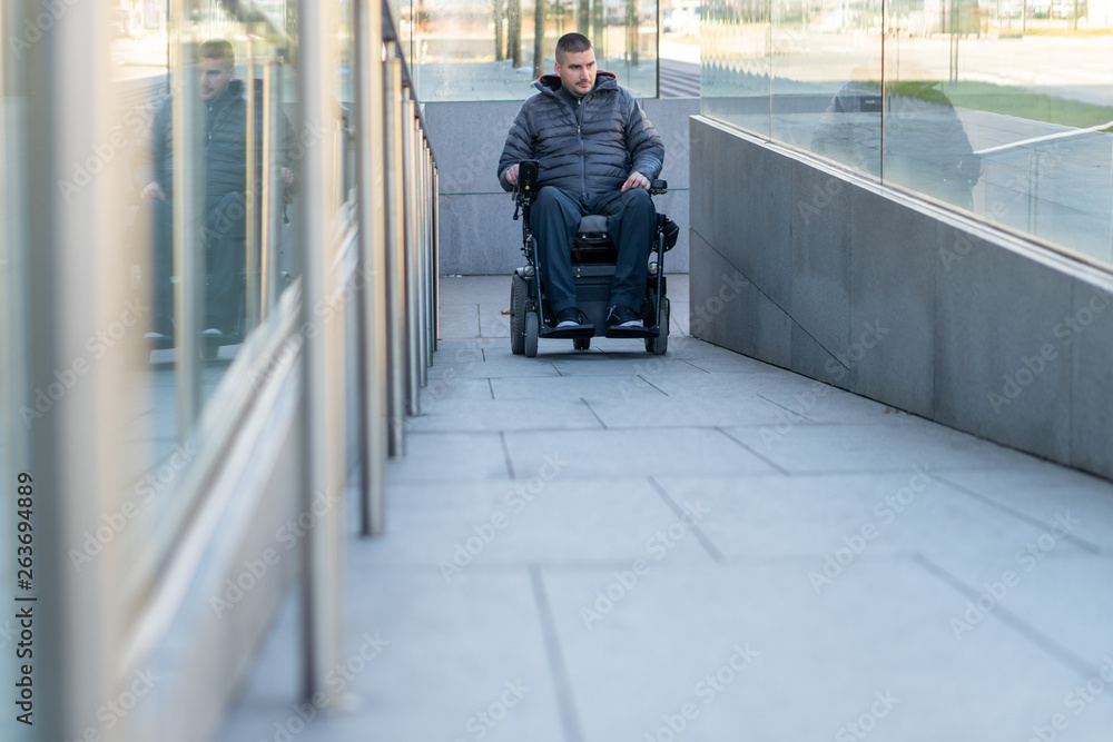 Man in a electric wheelchair using a ramp Man in a electric wheelchair using a ramp
