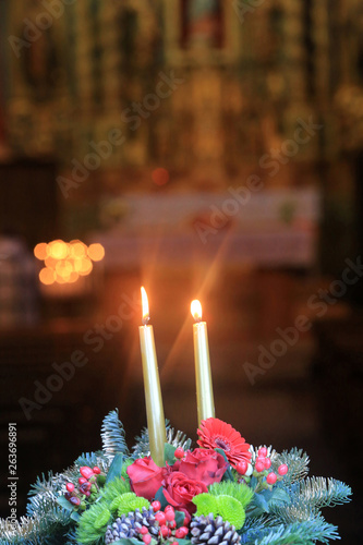 Cierges sur une couronne de fleurs. / Candles on a wreath. photo