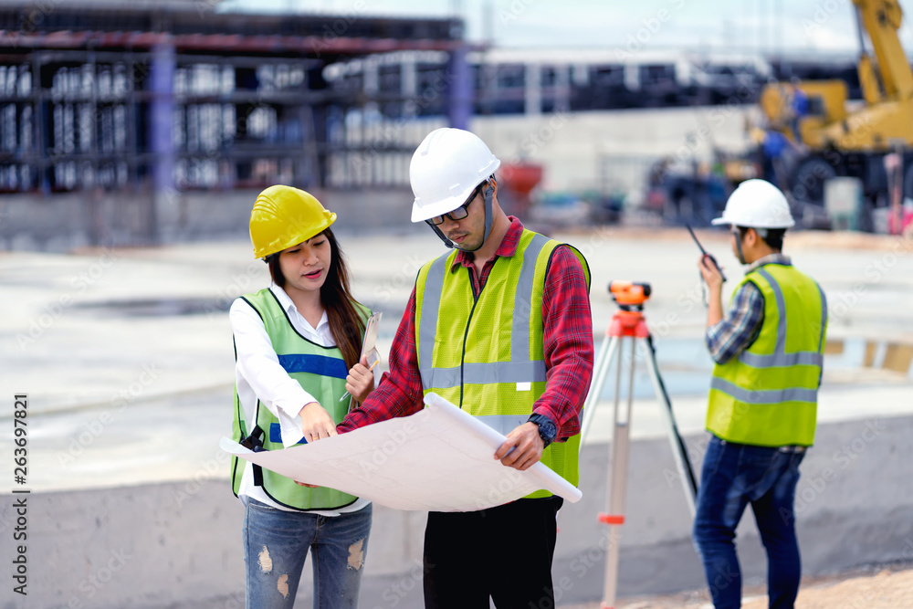 surveyor engineer with theodolite at construction site during surveying work.engineer and architect working at construction site with blueprint surveyor engineer with theodolite at construction site during surveying work.engineer and architect working at construction site with blueprint
