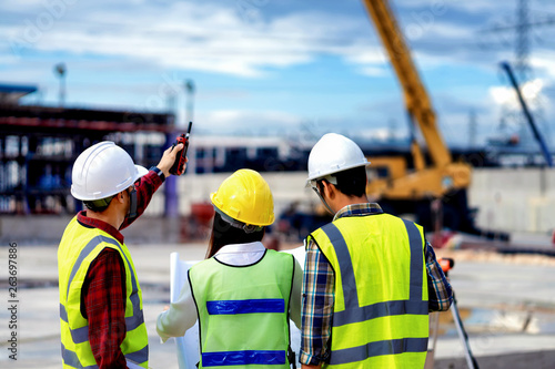 surveyor engineer with theodolite at construction site during surveying work.engineer and architect working at construction site with blueprint