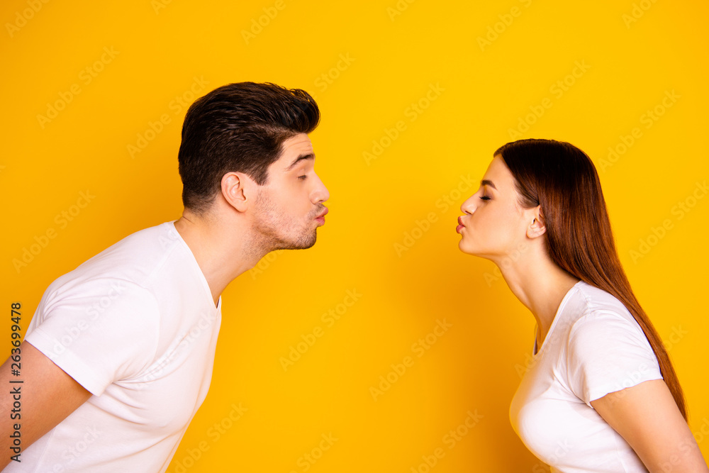 Close up side profile photo amazing beautiful she her he him his guy lady bonding ahead each other need kisses tenderness spread lips wear casual white t-shirts outfit isolated yellow background Close up side profile photo amazing beautiful she her he him his guy lady bonding ahead each other need kisses tenderness spread lips wear casual white t-shirts outfit isolated yellow background