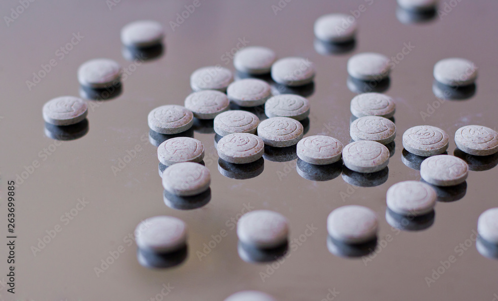 Tablets on a glossy metal surface. Tablets and vitamins for cats Tablets on a glossy metal surface. Tablets and vitamins for cats