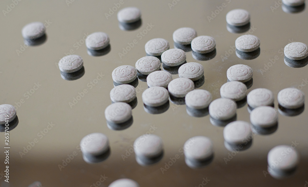 Tablets on a glossy metal surface. Tablets and vitamins for cats Tablets on a glossy metal surface. Tablets and vitamins for cats