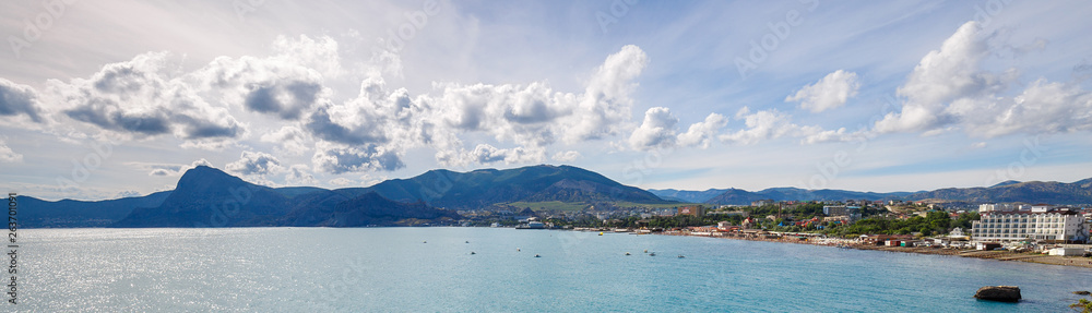 Beautiful view of the bay and seaside city from the height of the mountain trail. Seascape from a travel in the summertime. Panoramic banner.