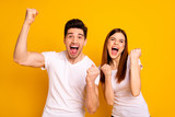 Portrait of two nice attractive lovely charming cheerful cheery people having fun lottery win winner best luck lucky isolated over vivid shine bright yellow background