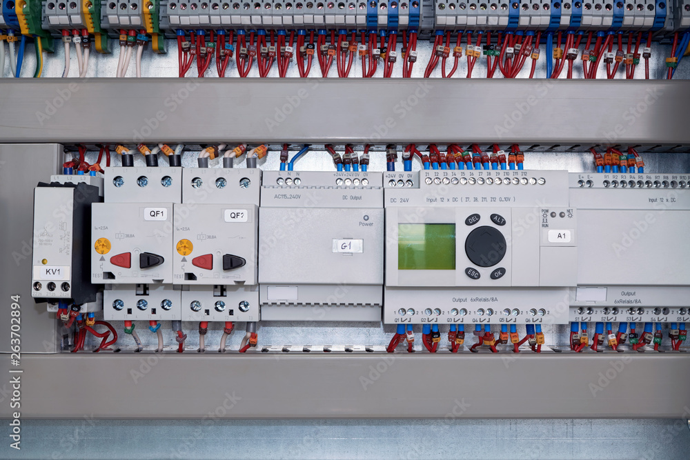 Phase control relay, motor protection circuit breaker, power supply and controller with input and output expansion unit in electrical Cabinet. Many wires connected to the scheme. Phase control relay, motor protection circuit breaker, power supply and controller with input and output expansion unit in electrical Cabinet. Many wires connected to the scheme.