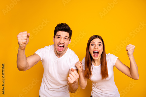 Portrait of two nice attractive lovely charming cheerful cheery ecstatic overjoyed people having fun good mood best lucky attainment isolated over vivid shine bright yellow background