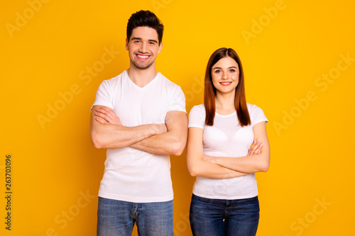 Close up photo beautiful cheer she her he him his pair stand side teamwork self-confident professionals specialists work job reliable workers wear casual white t-shirts isolated yellow background