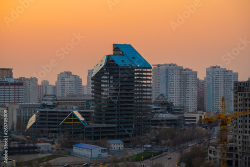 Dismantlement of blue glass skyscraper at sunset cityscape, broken down large abandoned building during demolition, Moscow