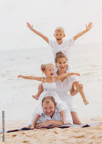 Happy young family on the sunset at the beach.