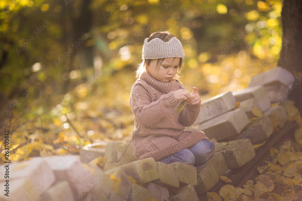 Funny girl child playing with maple in autumn park Funny girl child playing with maple in autumn park