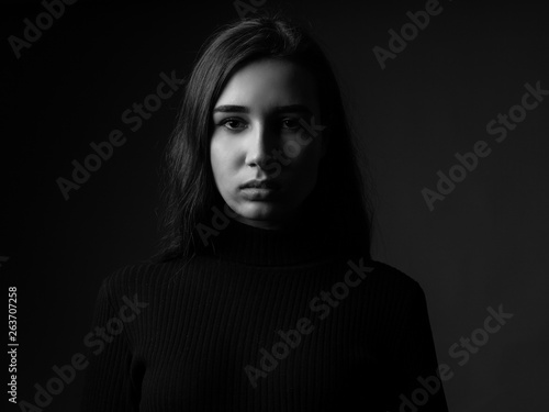 Portrait of a sad young woman. Black and white. Low key