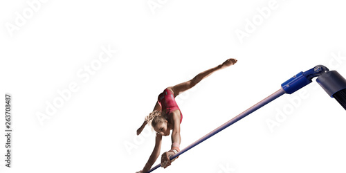 Female athlete doing a complicated exciting trick on horizontal gymnastics bars on white background. Isolated Girl perform stunt in bright sports clothes
