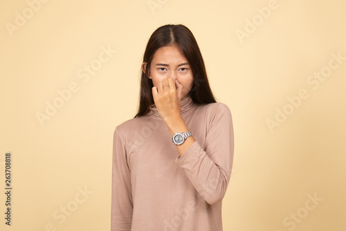 Canvas Print Young Asian woman  holding her nose because of a bad smell.