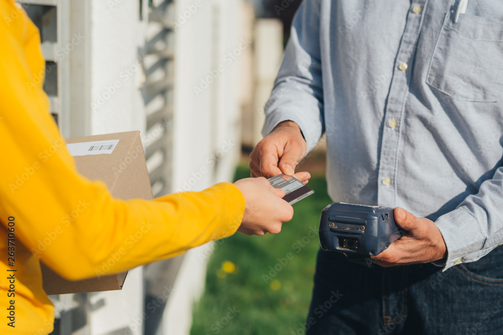 closeup of woman paying for package delivery service with visa card
