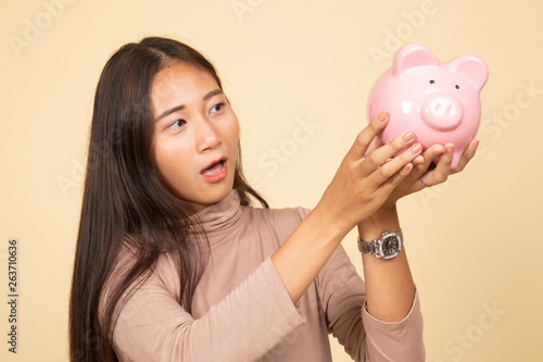 Young Asian woman with a pig coin bank.