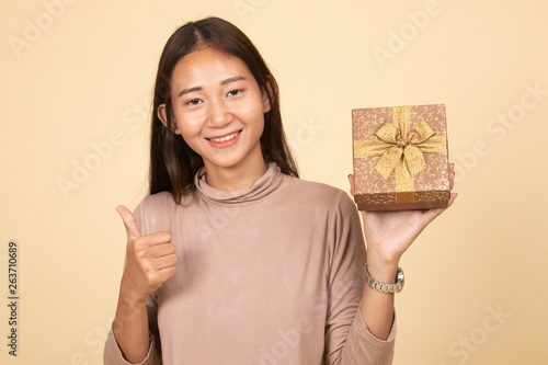 Asian woman thumbs up with a gift box.