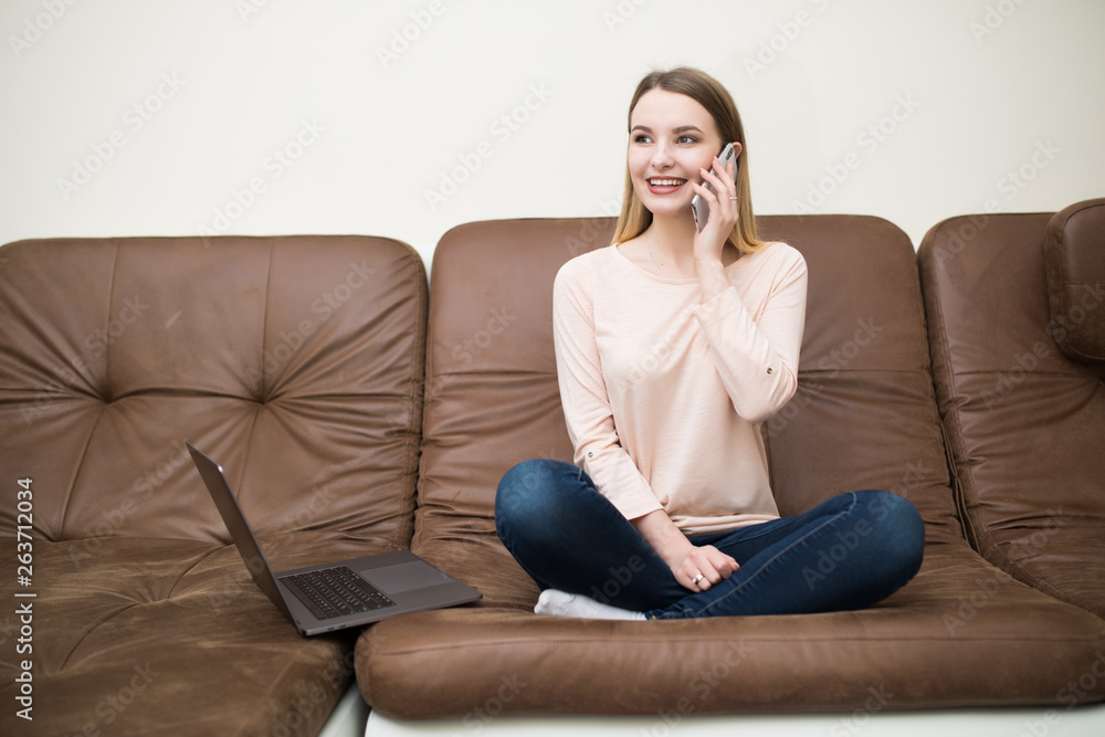 Young cheerful woman in couch talking on mobile phone Young cheerful woman in couch talking on mobile phone