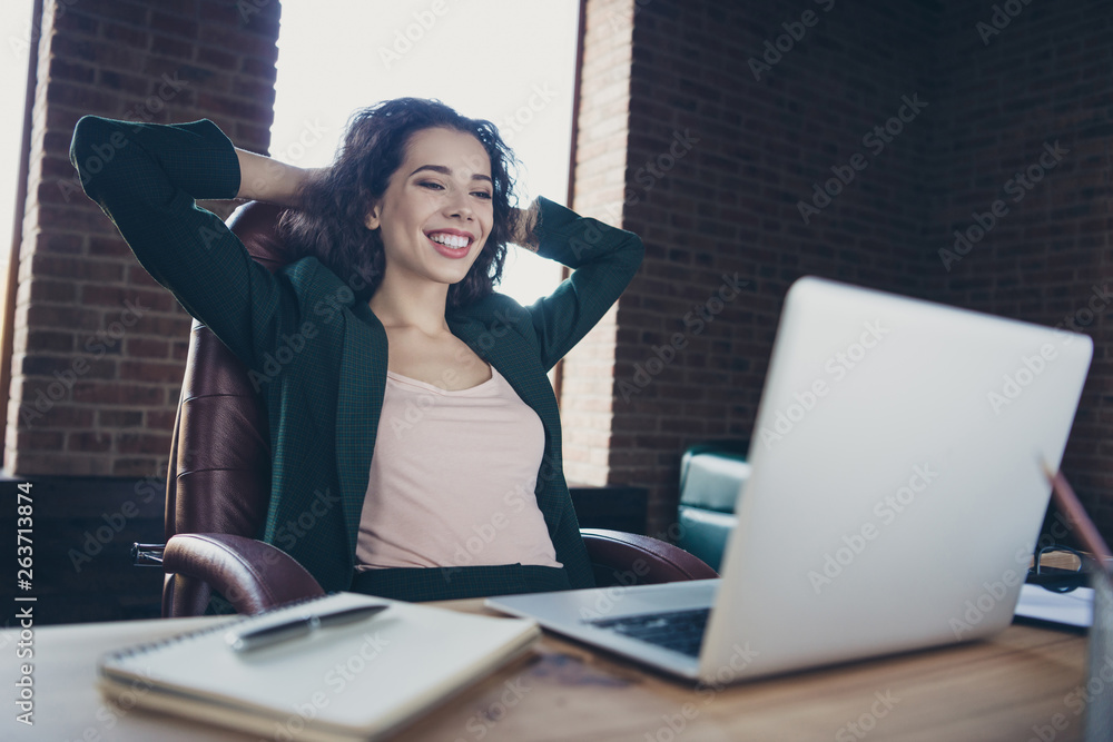 Obraz premium Close up photo of cute funny charming real estate agent enjoy leisure feel glad content have news in modern technology sit armchair jacket place hands arms behind head neck desktop in interior