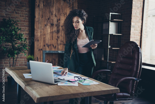 Portrait serious thoughtful executive real estate agent problem solve solution beautiful decide decision loft table desk chair armachair user modern technology hold hand black jacket curly wavy hair  photo