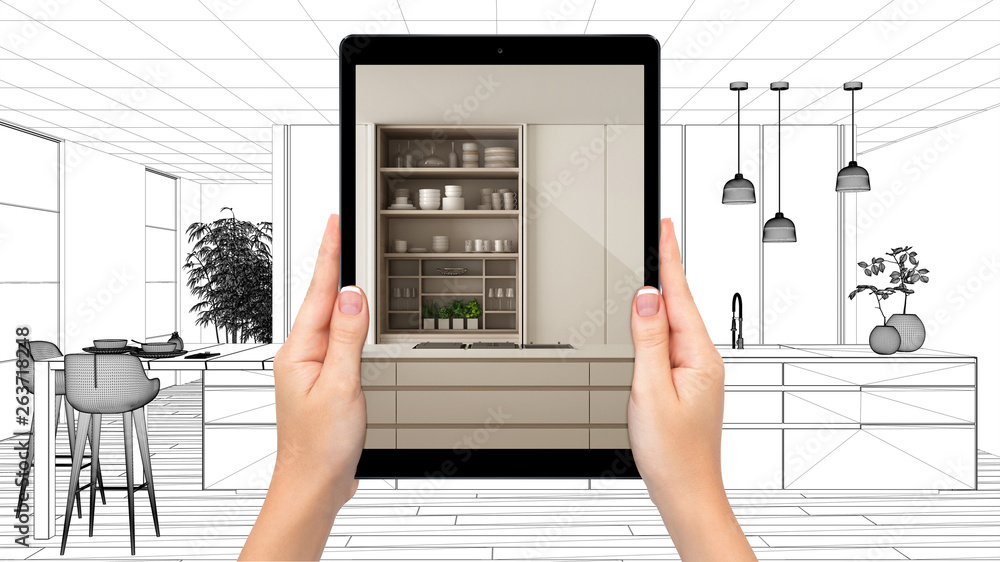 Hands holding tablet showing modern white and wooden kitchen. Blueprint CAD sketch background, augmented reality concept, application to simulate furniture and interior design products Hands holding tablet showing modern white and wooden kitchen. Blueprint CAD sketch background, augmented reality concept, application to simulate furniture and interior design products