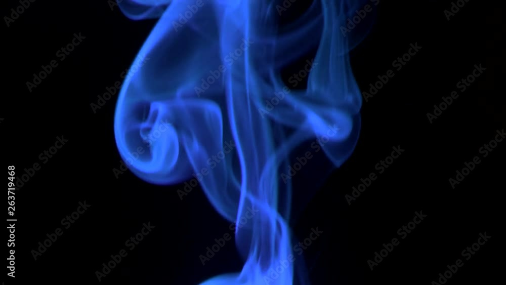 Trickle neon-blue smoke slowly rising graceful twists upward. Colored smoke blowing from bottom to top. Close-up, isolated on black background Trickle neon-blue smoke slowly rising graceful twists upward. Colored smoke blowing from bottom to top. Close-up, isolated on black background