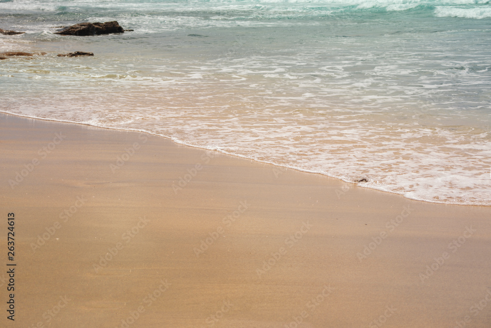 Blue ocean wave on the blond sandy beach. Heavenly background.