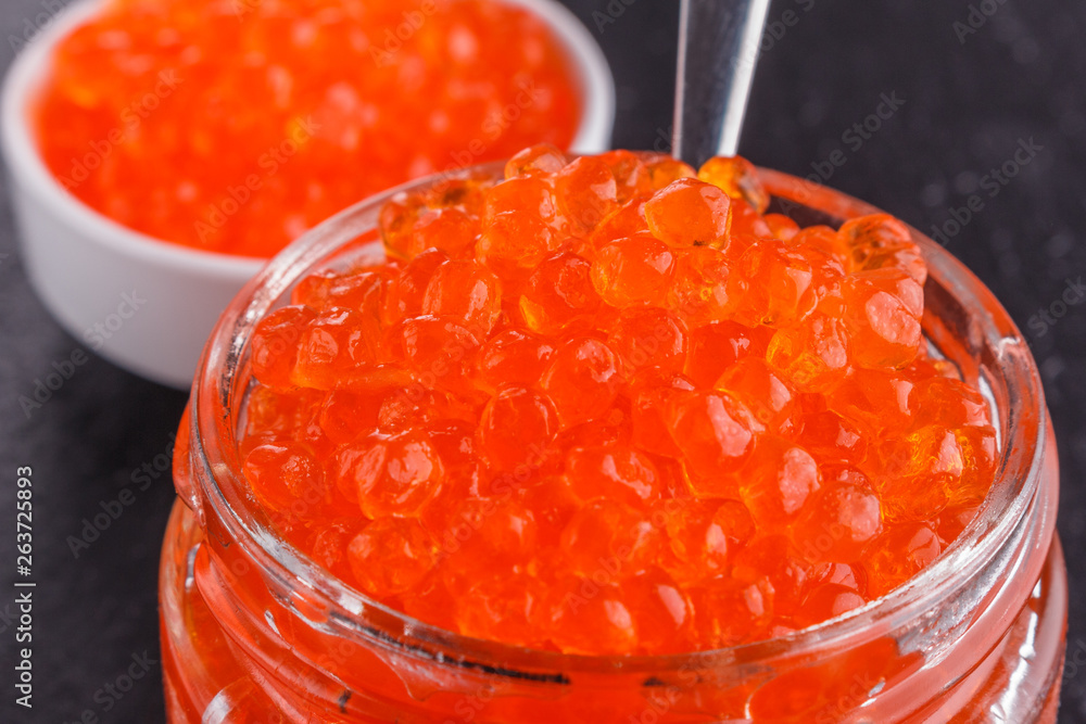red caviar in a bowl on a dark stone background red caviar in a bowl on a dark stone background