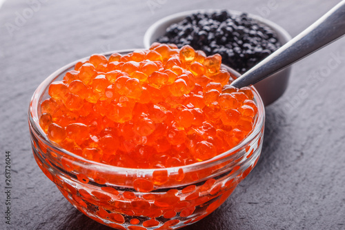 red and black caviar in a bowl on a dark stone background