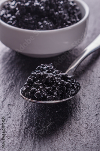black caviar in a bowl on a dark stone background