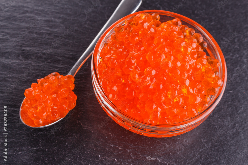 red caviar in a bowl on a dark stone background red caviar in a bowl on a dark stone background