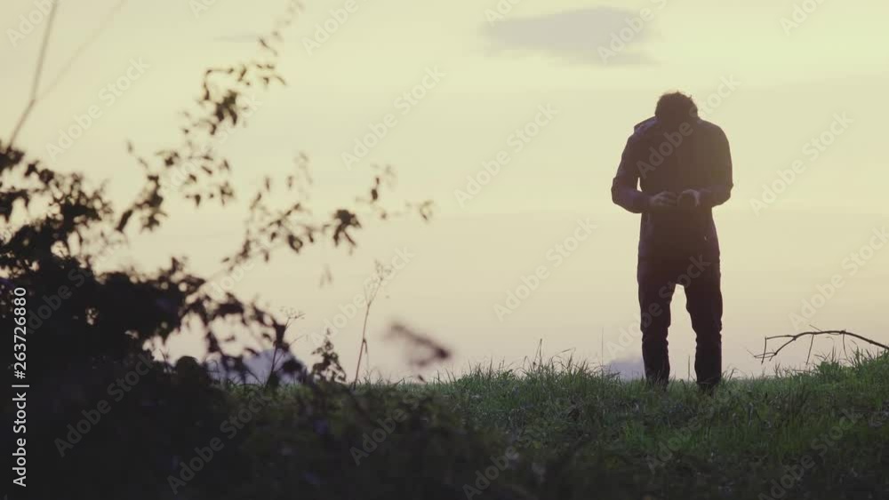 A videographer films a outdoor scene at sunset in a nice landscape location A videographer films a outdoor scene at sunset in a nice landscape location