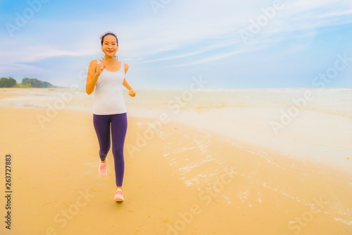 Portrait beautiful young sport asian woman exercise by run and jogging on the outdoor nature beach and sea © siraphol