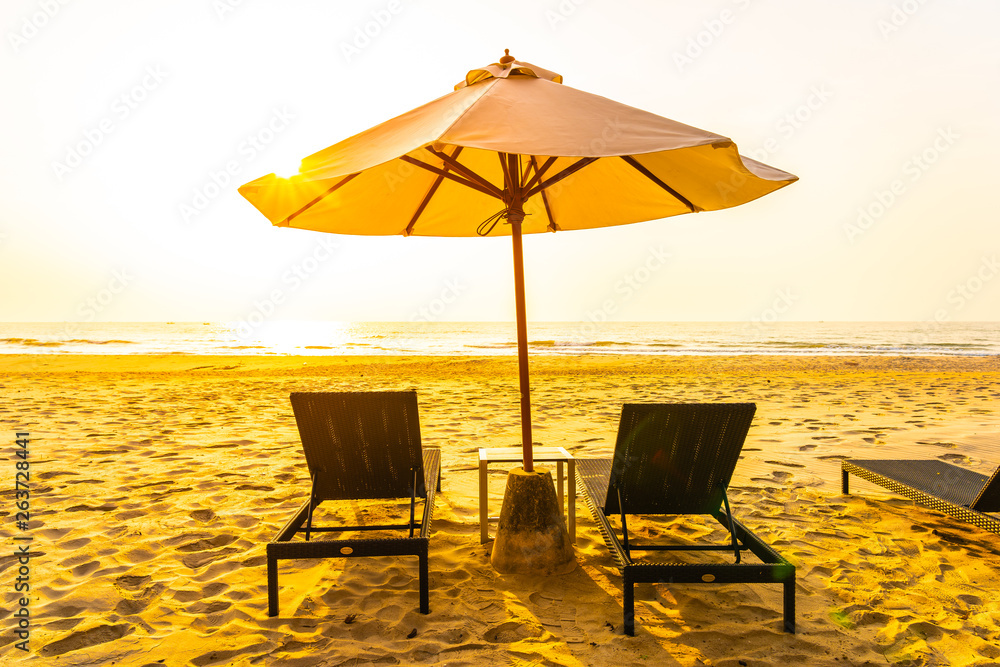 Umbrella and chair on the beautiful landscape of beach sea ocean at sunrise or sunset time