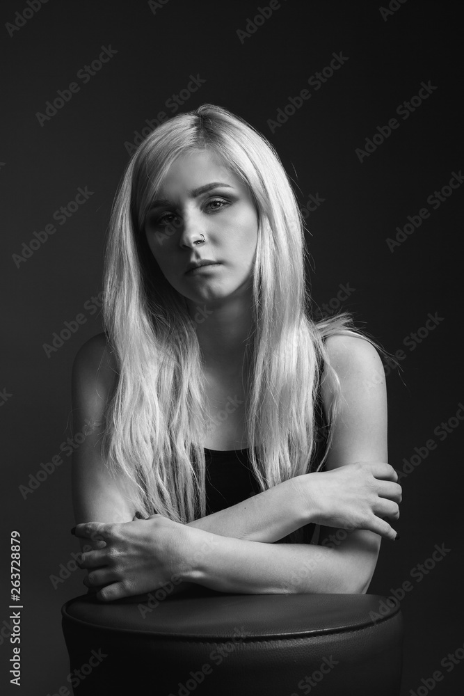 Portrait of the blonde young woman on black background. Black and white Portrait of the blonde young woman on black background. Black and white