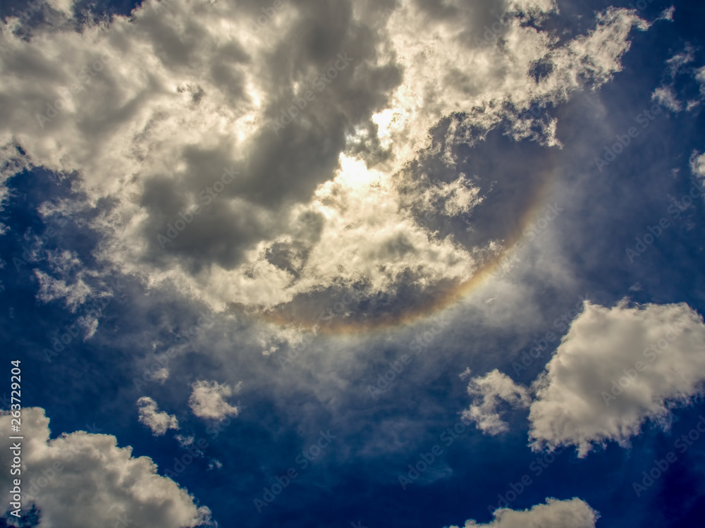 Fototapeta premium A part of a solar halo shows up trought the midday clouds over the Andean mountains of central Colombia.